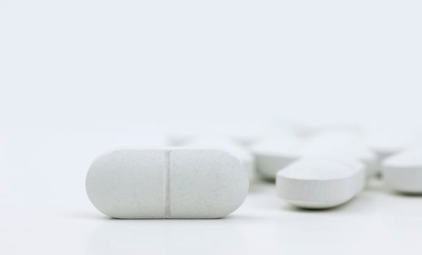Close-up of white tablets representing dual antiplatelet therapy, such as aspirin and clopidogrel, for minor stroke and high-risk TIA prevention