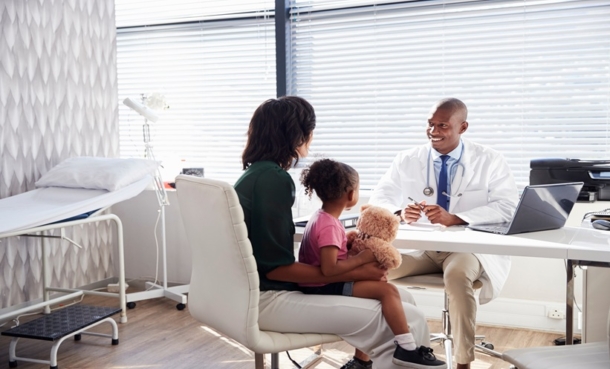 Doctor speaking with a mother and child during a clinic visit for juvenile localized scleroderma care.