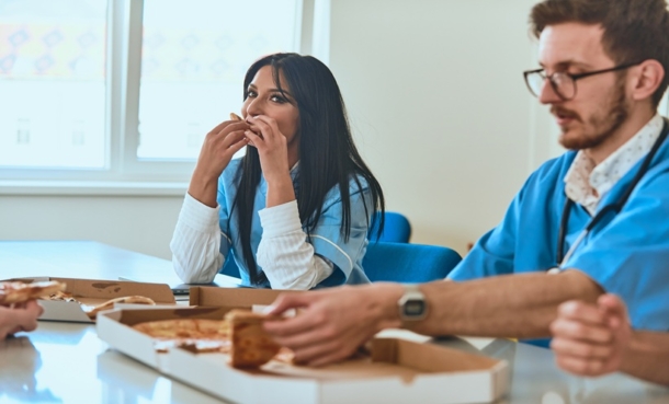 Healthcare workers in a hospital break room, illustrating Mediterranean diet non-adherence linked to workplace stress and hectic schedules