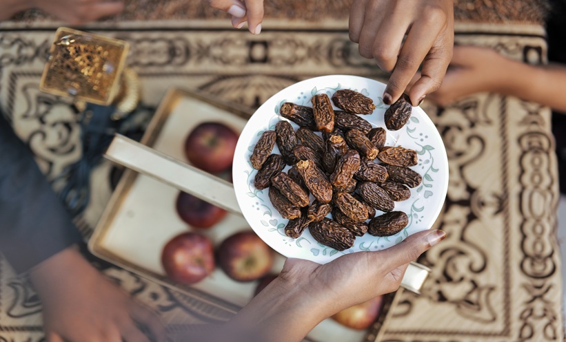 Adults sharing an evening meal during Ramadan, illustrating social support in dietary behavior change.