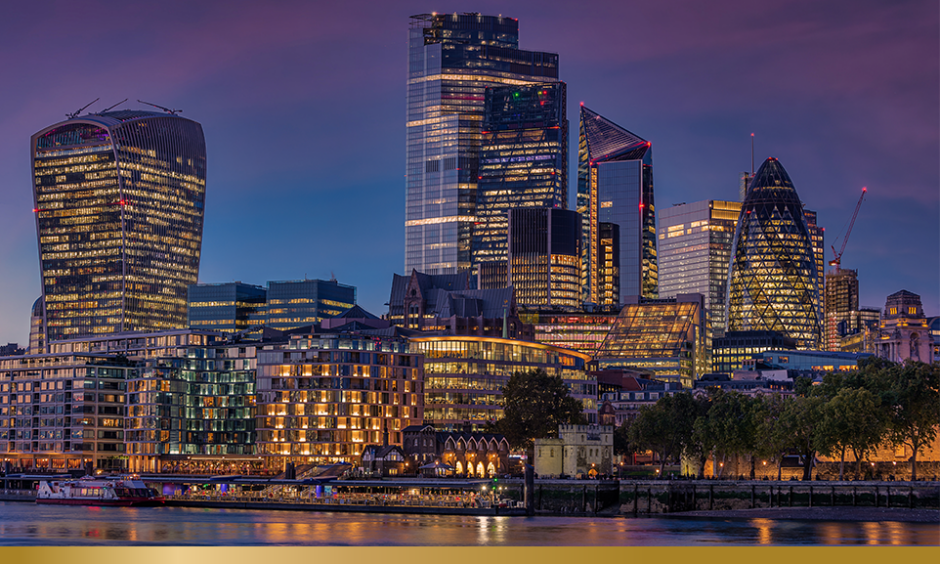 A photograph of the Thames river and City of London skyline at night