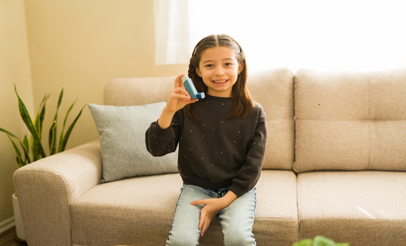 Little girl holding an asthma inhaler.