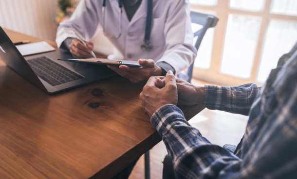 Clinician preparing a patient for prostate biopsy under local anaesthesia in an outpatient setting