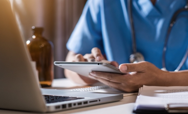 Clinician reviewing Pompe disease management options on a tablet with patient in consultation room