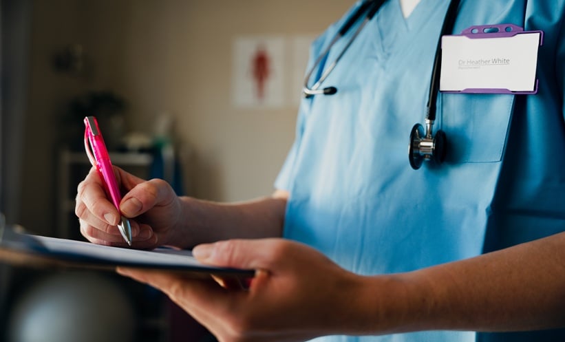 Advanced practice nurse discussing chronic migraine treatment scheduling with a patient during a neurology clinic visit.