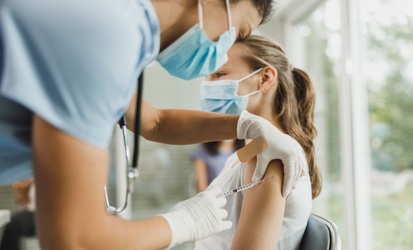 Clinician preparing RSV vaccination for an immunocompromised patient during a respiratory virus season visit.