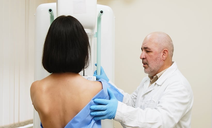 Breast cancer patient undergoing mammography during clinical imaging assessment