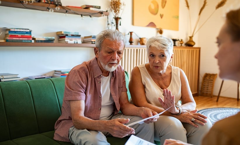 Older adult reviewing paperwork with a caregiver, illustrating practical judgment in aging and decision making.