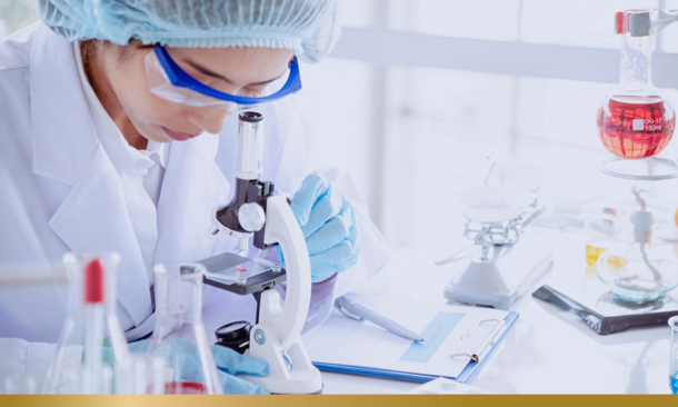 Woman in lab looking at microscope