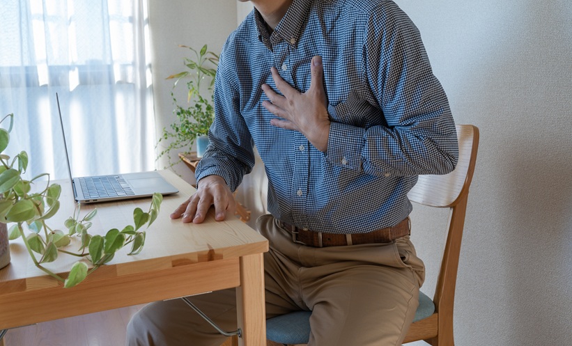 Out of breath man grasping his chest.