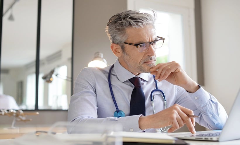 Oncologist reviewing next-generation sequencing results and genomic testing data for a patient with advanced cancer.
