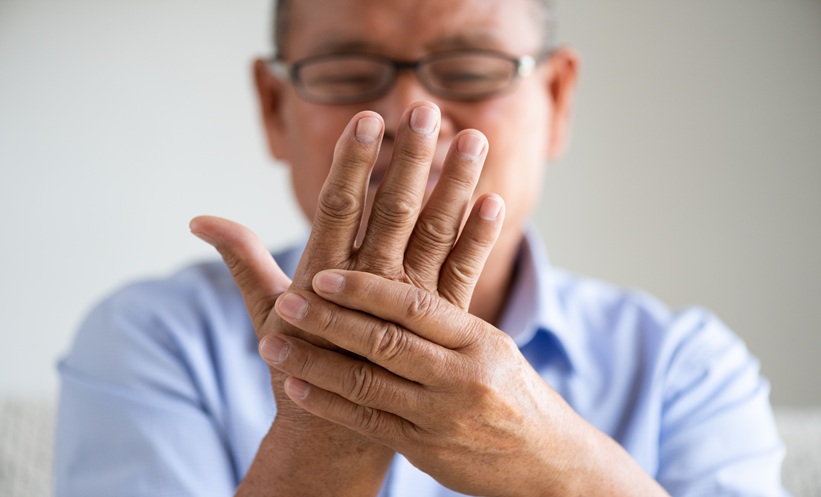 Clinician assessing hand tremor in a patient with essential tremor during a neurology visit