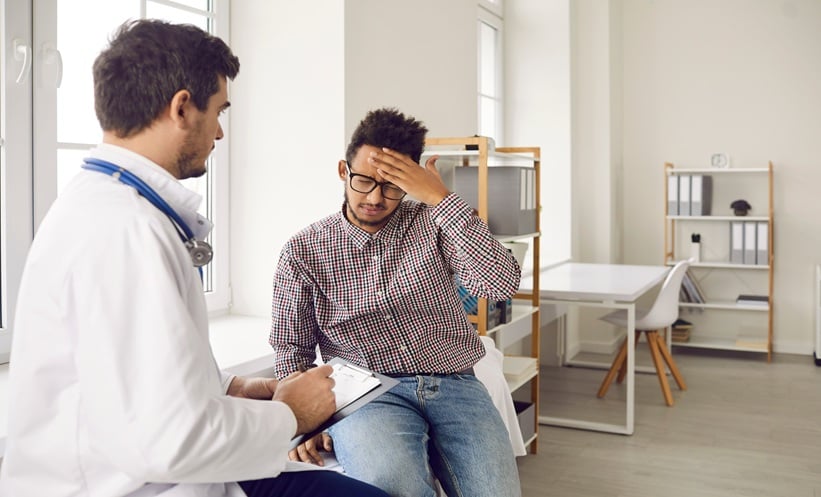 Patient discussing galcanezumab migraine prevention with a clinician during a neurology consultation