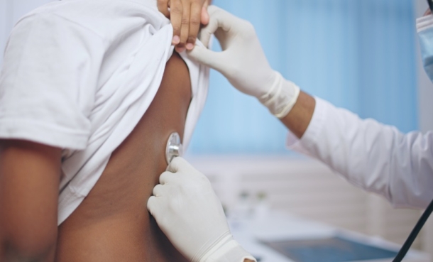 Doctor examining a patient's lungs using a stethoscope.