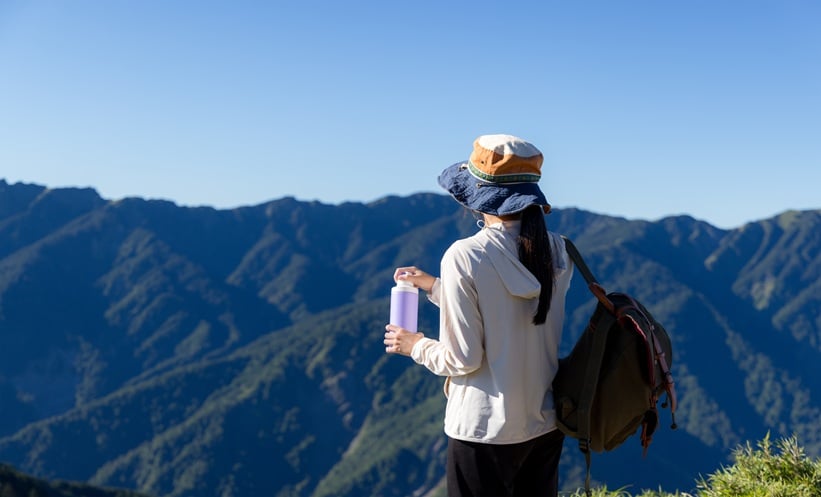Traveler drinking safe bottled water while preparing for travel to a cholera risk area