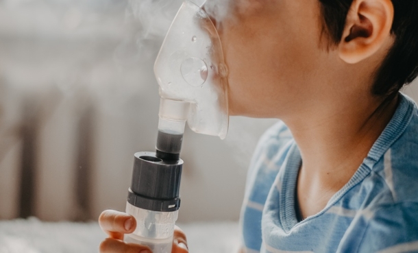 Little boy breathing from a nebulizer.