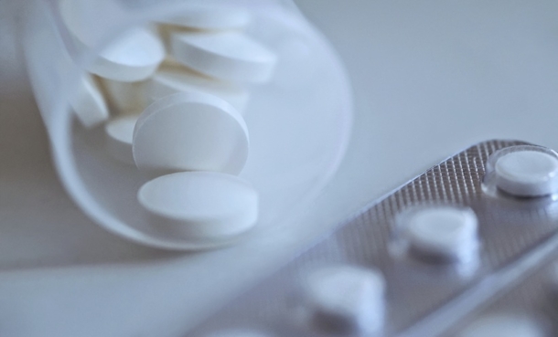 Close-up of white tablets and blister pack representing aspirin use in stroke prevention.