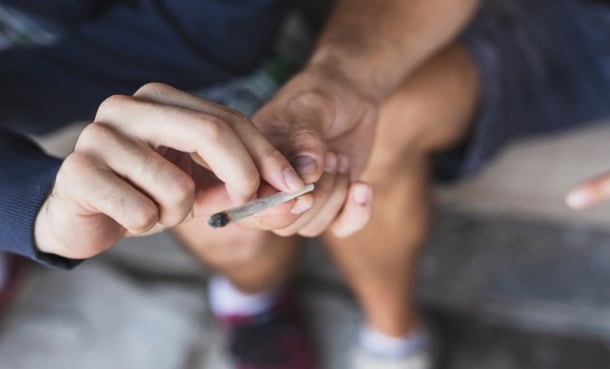 Person holding a cannabis joint, illustrating cannabis use disorder risk by mode of use.