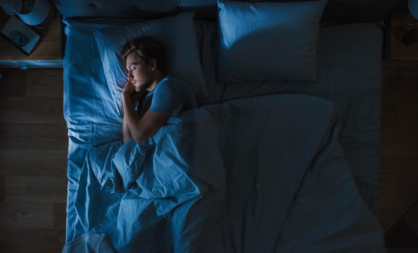 Adult sleeping in bed, representing sleep apnea hypoxic burden and emotion recognition.