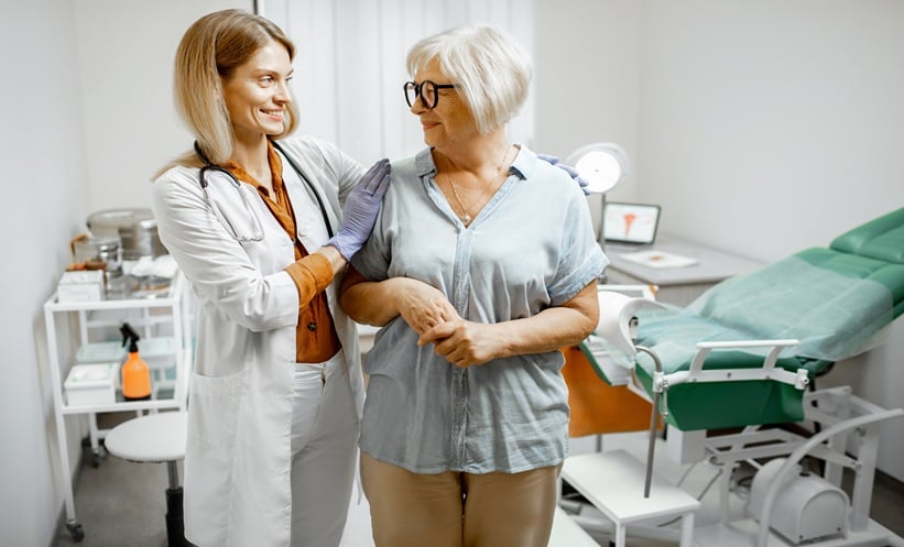 Clinician supporting an older woman during a consultation about HIV menopause care.
