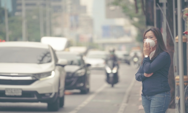 Air pollution and tinnitus risk illustrated through a city skyline and hearing health concept.