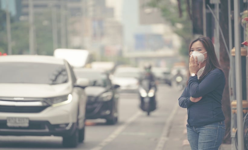 Air pollution and tinnitus risk illustrated through a city skyline and hearing health concept.