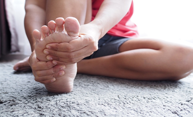 Patient holding foot in discomfort, representing gout flare resolution and recovery from joint pain
