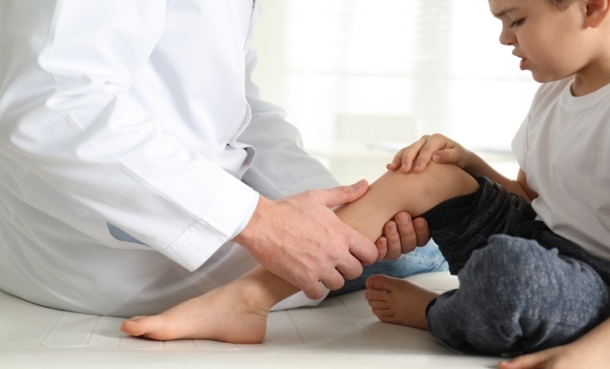 Child undergoing knee assessment for rice body synovitis and juvenile idiopathic arthritis evaluation.