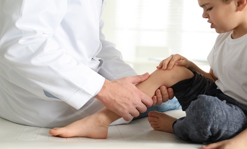 Child undergoing knee assessment for rice body synovitis and juvenile idiopathic arthritis evaluation.