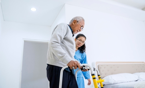 Patient undergoing stroke rehabilitation with clinician support, representing new-onset constipation after stroke and recovery outcomes.