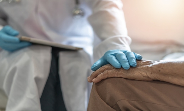 Healthcare professional supporting an older patient during consultation about leprosy quality of life and stigma.