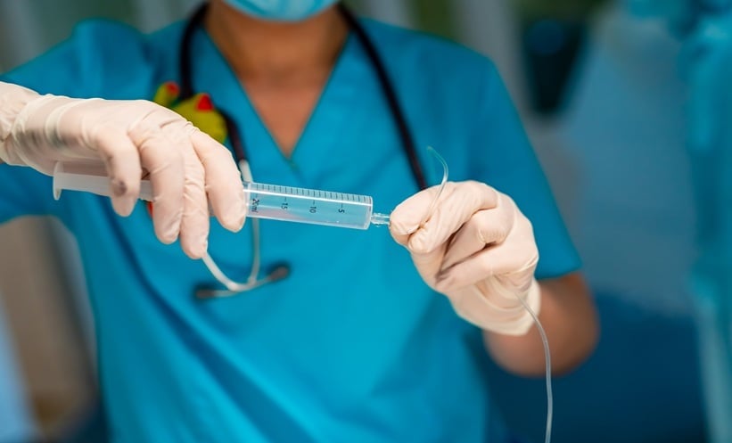 Clinician preparing medical equipment during care for complex Crohn’s disease.