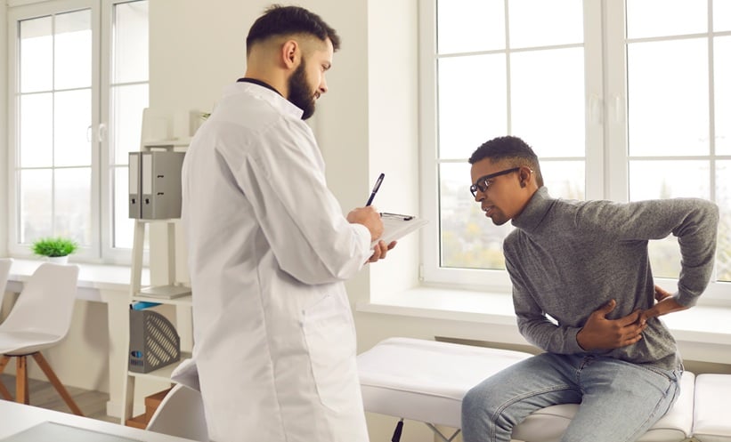 Doctor discussing rheumatoid arthritis treatment timing with a patient during a clinical consultation.