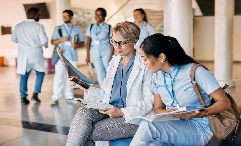 Early-career rheumatology nurse reviewing patient care notes in a county hospital setting