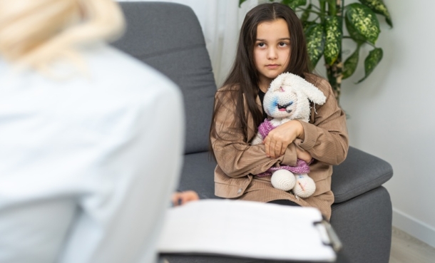 Physician discussing cognitive screening and childhood lupus care with a young patient and caregiver.