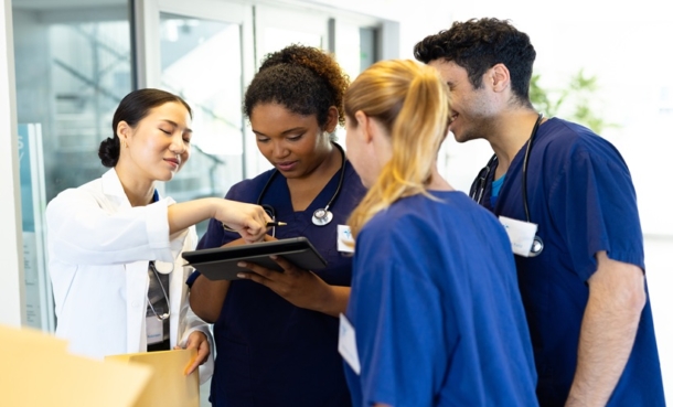Rheumatology nurses discussing automatic substitution of biological medicines with a patient in a clinical setting.