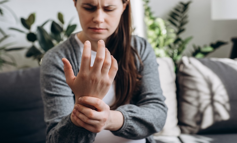 Patient holding wrist during psoriatic arthritis flare and treatment discussion