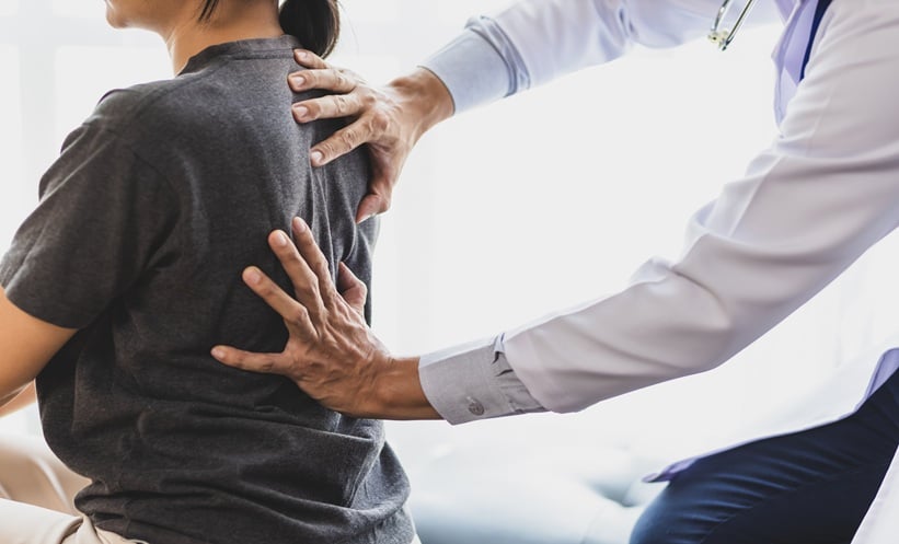 Physician discussing cancer-related bone pain treatment with a patient in clinic