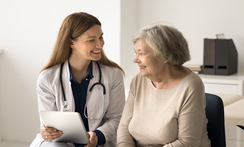 Clinician reviewing digital gout management information with a patient using a tablet.