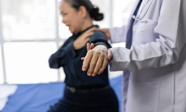 Clinician assessing hand and wrist trauma follow-up as attrition rates are reviewed in clinical trials.