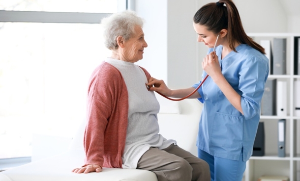 Doctor listening to an older patient’s lungs during a respiratory consultation for bronchiectasis care.