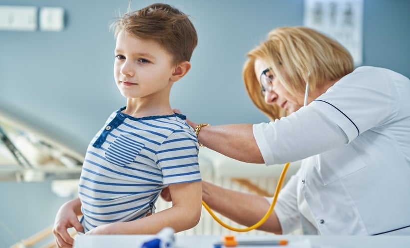 Pediatrician examining a child in clinic, representing CFTR modulator care and mental health in cystic fibrosis.