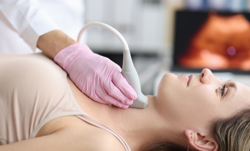 Clinician performing neck ultrasound as part of head and neck cancer assessment.
