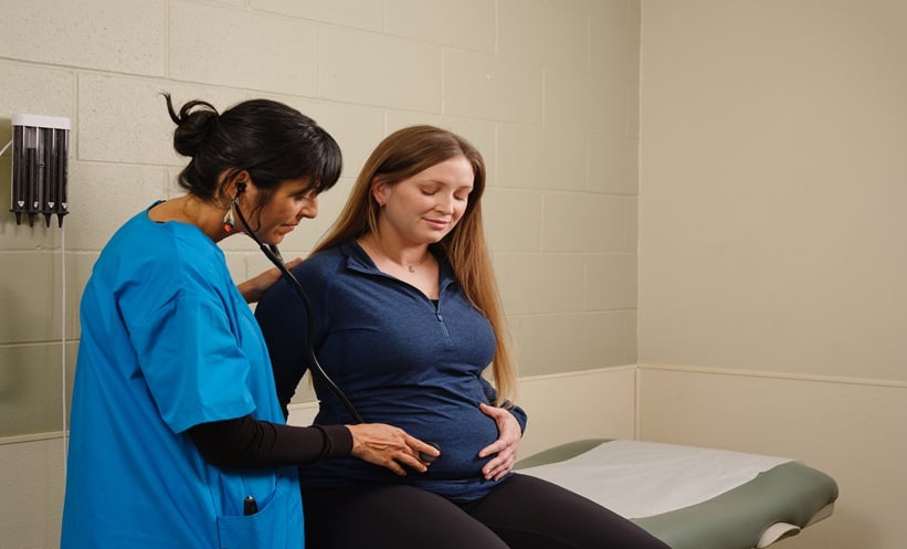 healthcare provider caring for pregnant woman in clinic