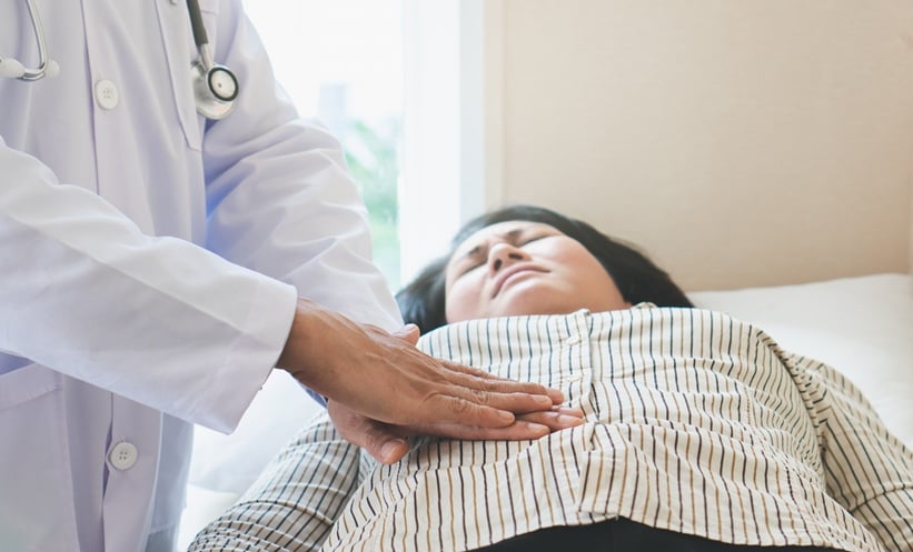 mining stomach of woman patient and pressing hands on her belly.