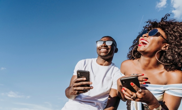 Young adults viewing a sun safety campaign promoting sunscreen use and skin cancer prevention.