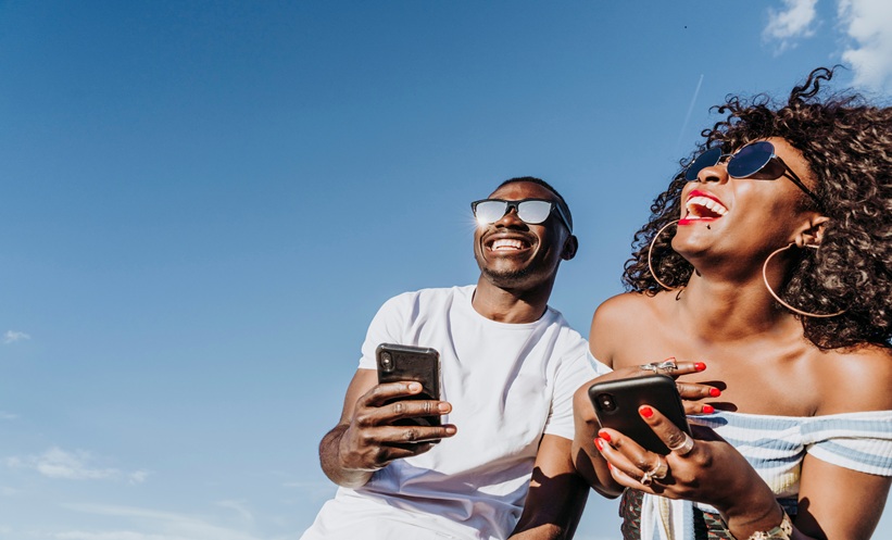Young adults viewing a sun safety campaign promoting sunscreen use and skin cancer prevention.
