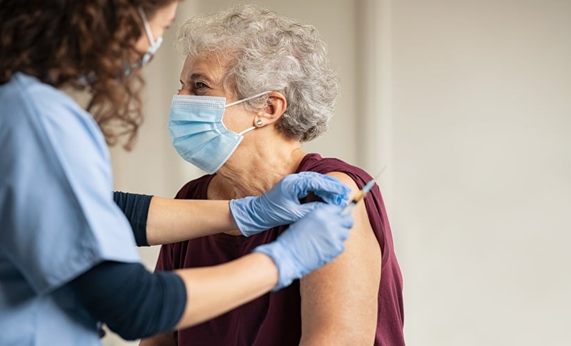 Healthcare professional giving vaccination to a vulnerable patient.