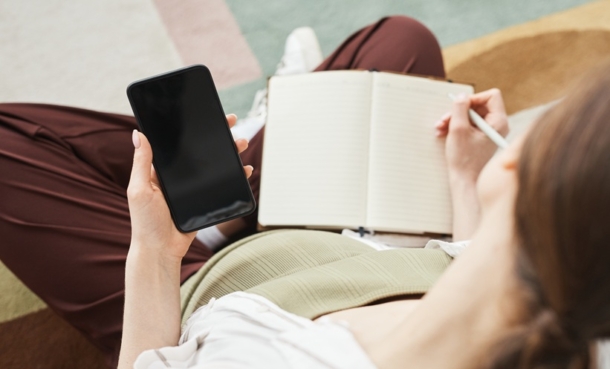 Pregnant woman using a smartphone for web-based intervention support during prenatal care.