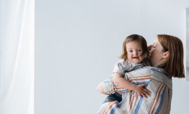 Mother holding a young child, illustrating early childhood health and atopic dermatitis research.